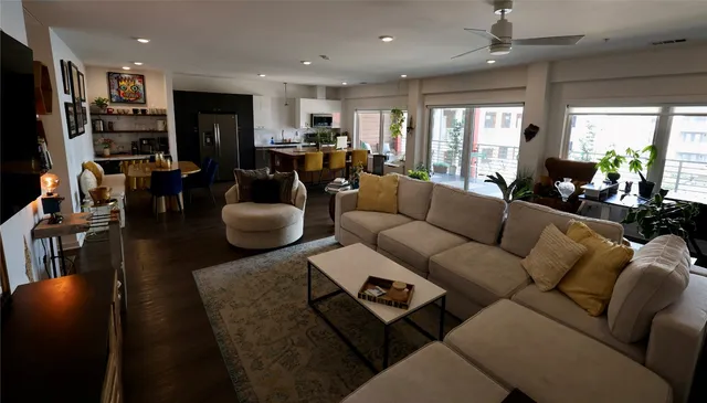 a living room with furniture a flat screen tv and a large window
