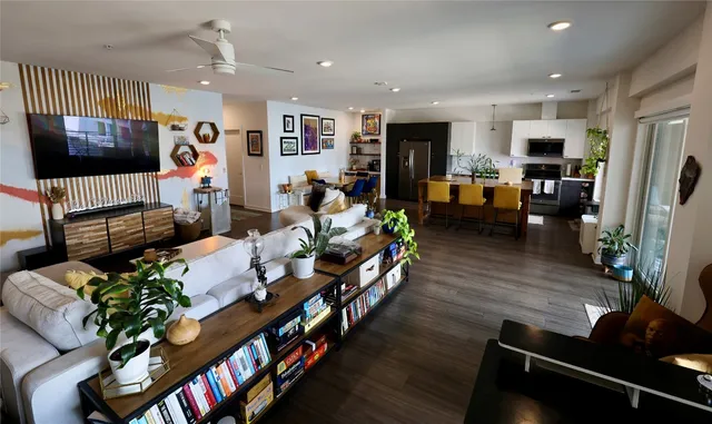 a living room with furniture flat screen tv and a potted plant
