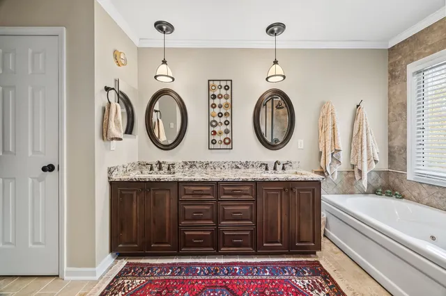 a bathroom with a granite countertop sink and a large mirror