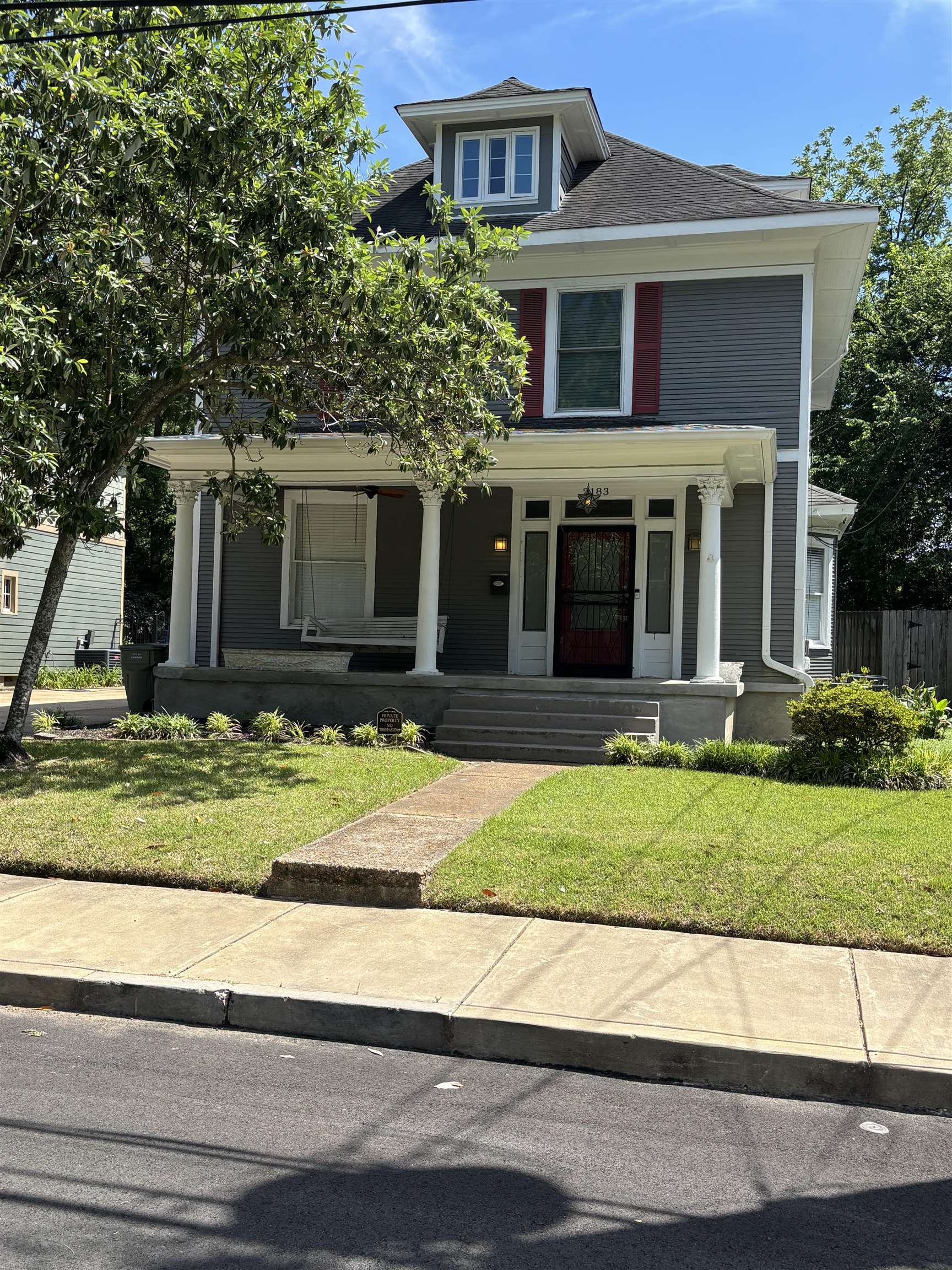 2183 Harbert Avenue Memphis, TN 38104 - Photo 1 of 1 Two-story residence featuring a prominent front porch with columns, dormer window, and gray siding