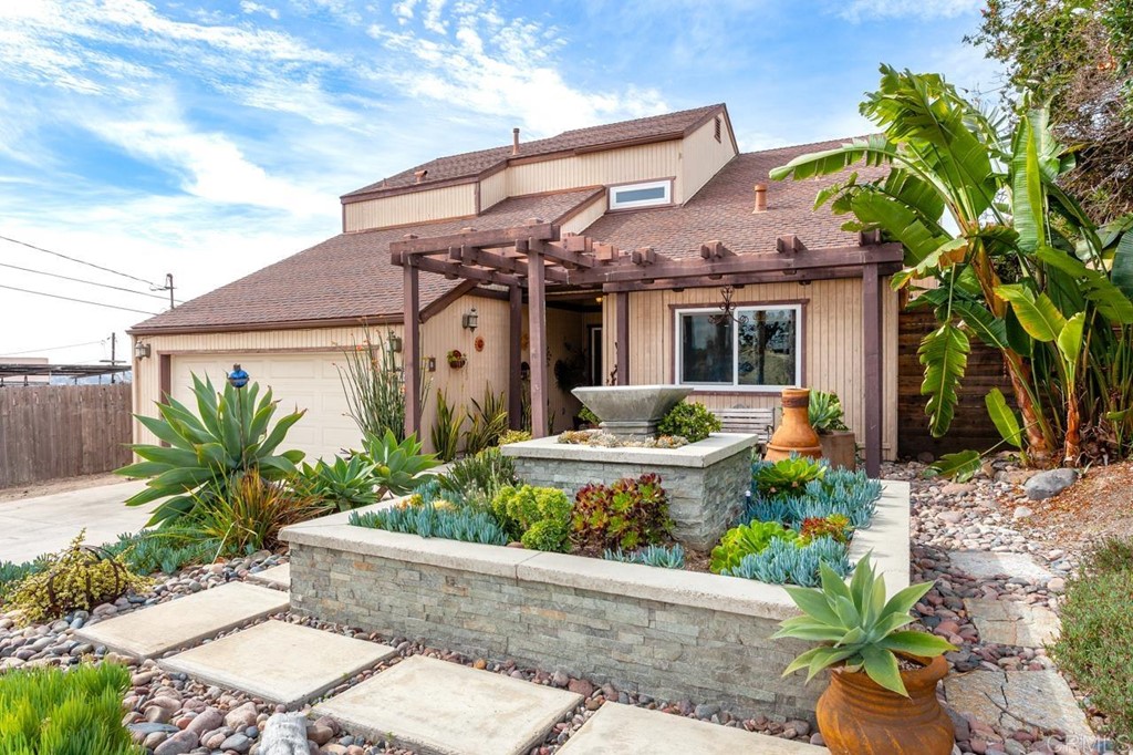 a front view of a house with a garden