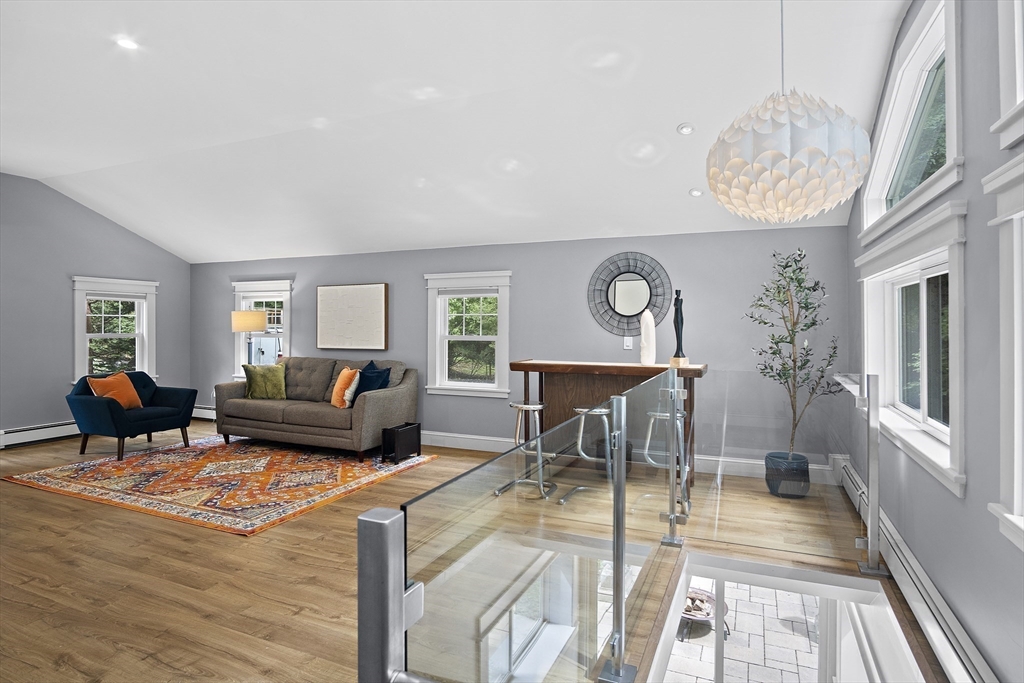 80 Evergreen Road Natick, MA 01760 - Photo 8 of 39 a living room with furniture a dining table and a chandelier