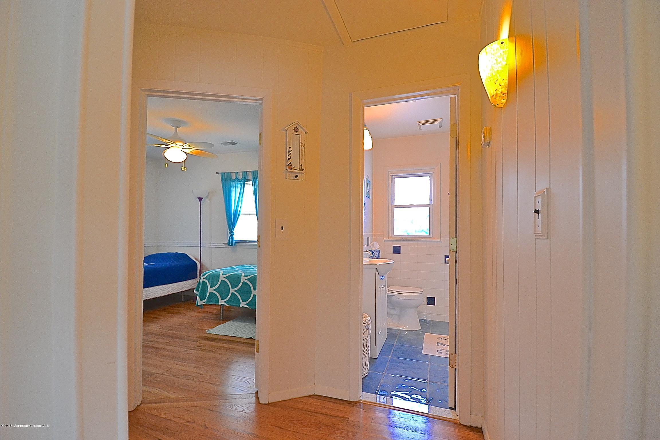 45 North Island Road Bayville, NJ 08721 - Photo 17 of 31 a view of a hallway with wooden floor and a chandelier