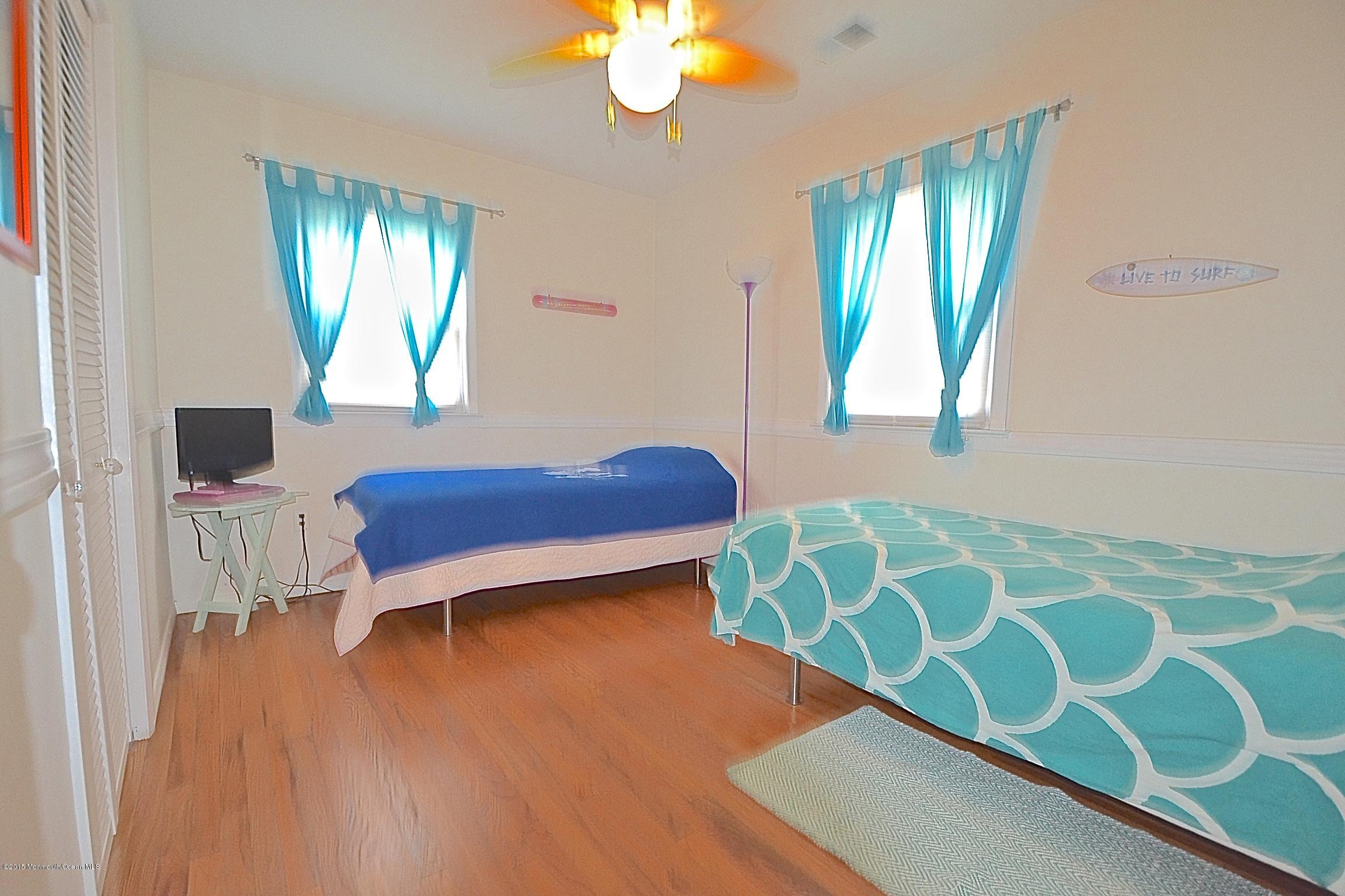 45 North Island Road Bayville, NJ 08721 - Photo 20 of 31 a bedroom with a bed and a chandelier