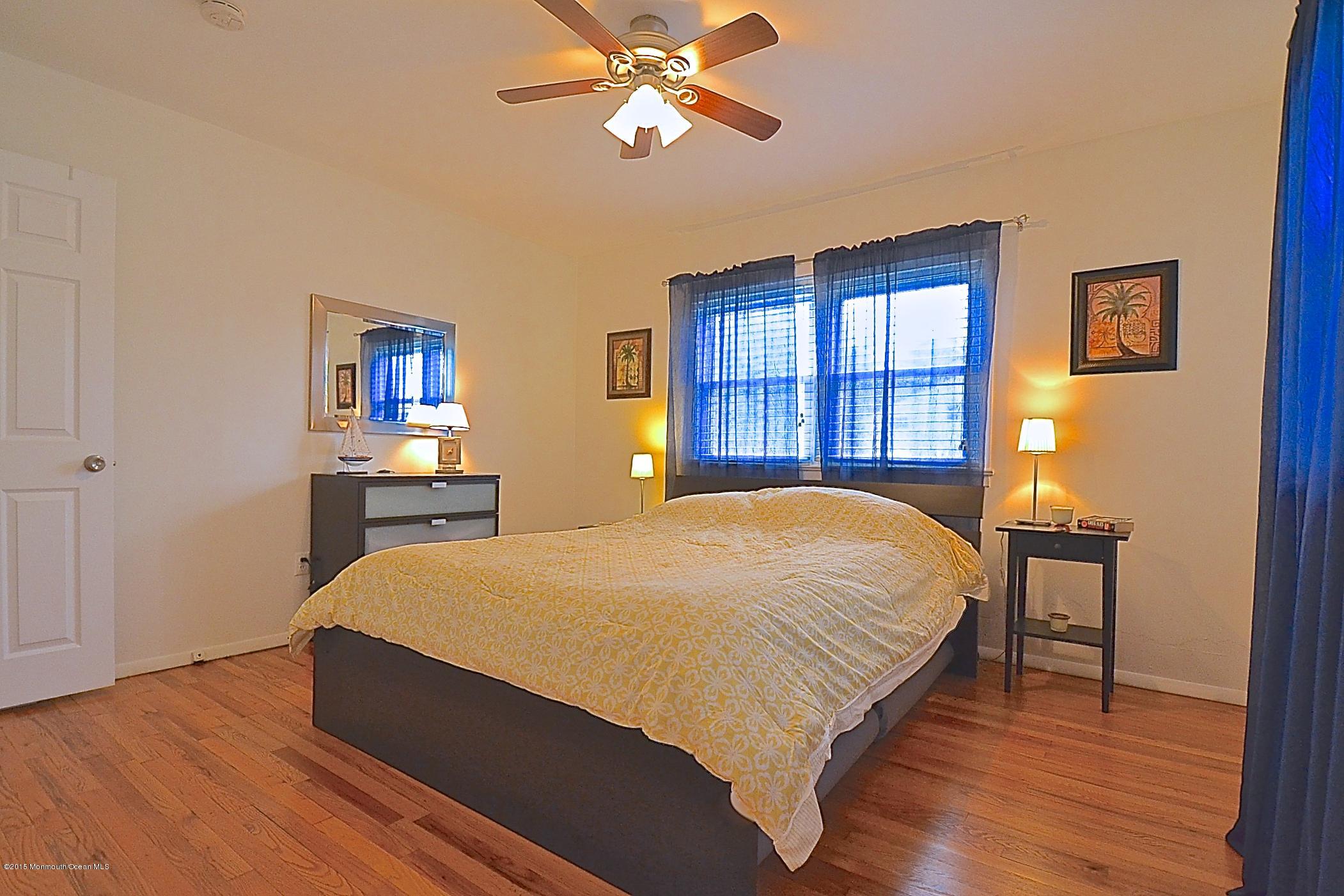 45 North Island Road Bayville, NJ 08721 - Photo 22 of 31 a bed sitting in a bedroom next to a window and a chandelier