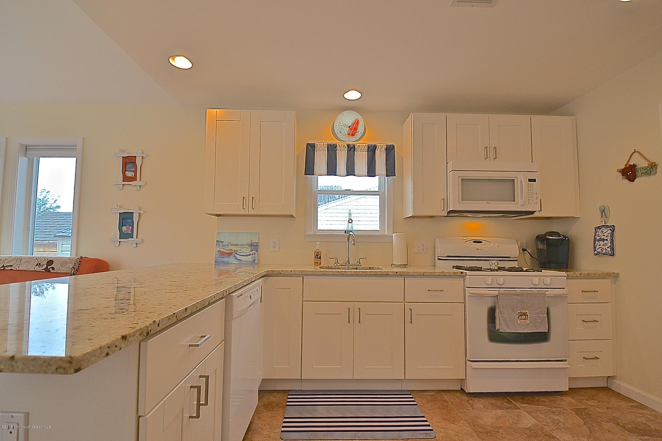 45 North Island Road Bayville, NJ 08721 - Photo 4 of 31 a kitchen with white cabinets and white appliances