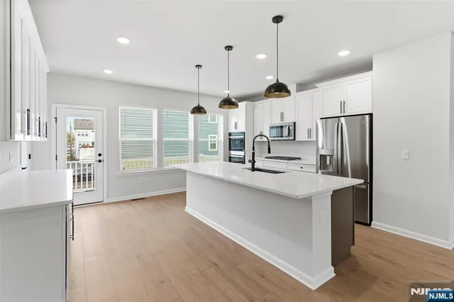a kitchen with stainless steel appliances a sink stove and refrigerator