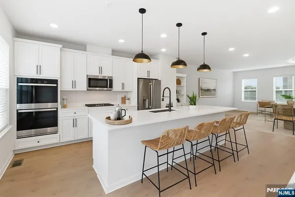 a kitchen with stainless steel appliances kitchen island a large island in the center