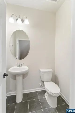 a bathroom with a sink a toilet and mirror