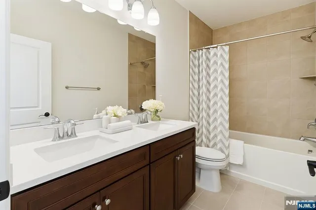 a bathroom with a double vanity sink toilet and shower