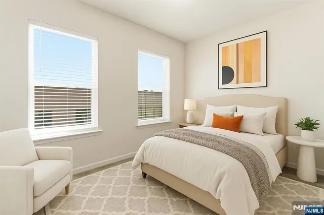 a bedroom with a bed and a couch next to a window