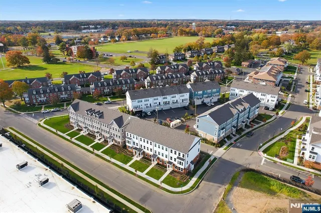 an aerial view of a house with a garden and lake view