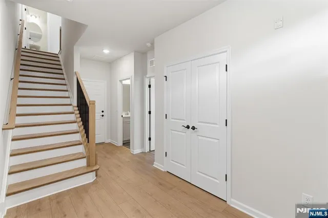 a view of a hallway with entryway and stairs