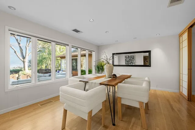 a living room with furniture dining table and a large window