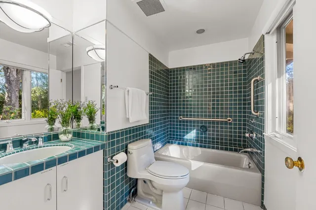 a bathroom with a granite countertop sink mirror vanity and bathtub