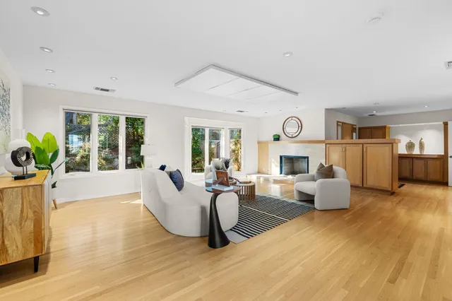 a living room with fireplace furniture and a large window
