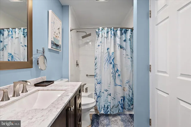 a bathroom with a granite countertop shower sink and mirror