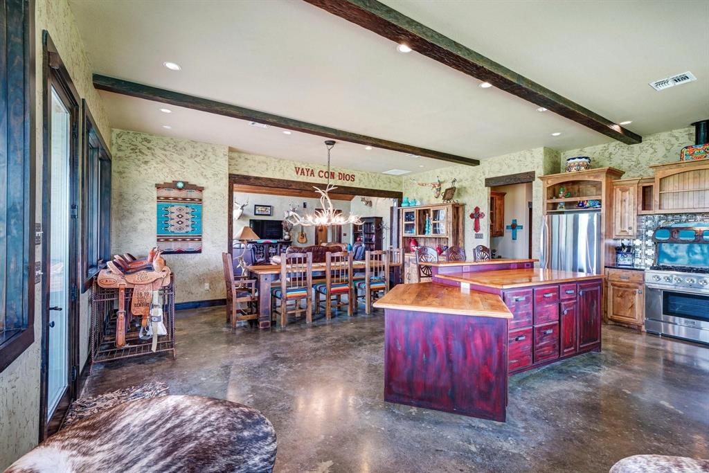 1084 Beddo Mountain Road Santo, TX 76472 - Photo 9 of 40 a large living room with stainless steel appliances kitchen island granite countertop a table chairs and a large window