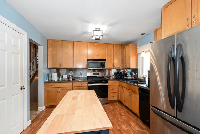 a kitchen with stainless steel appliances granite countertop a refrigerator a stove top oven a sink and dishwasher