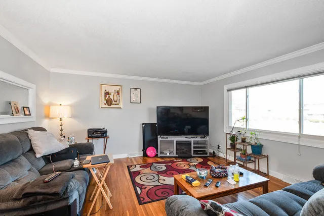 a living room with furniture a flat screen tv and a window