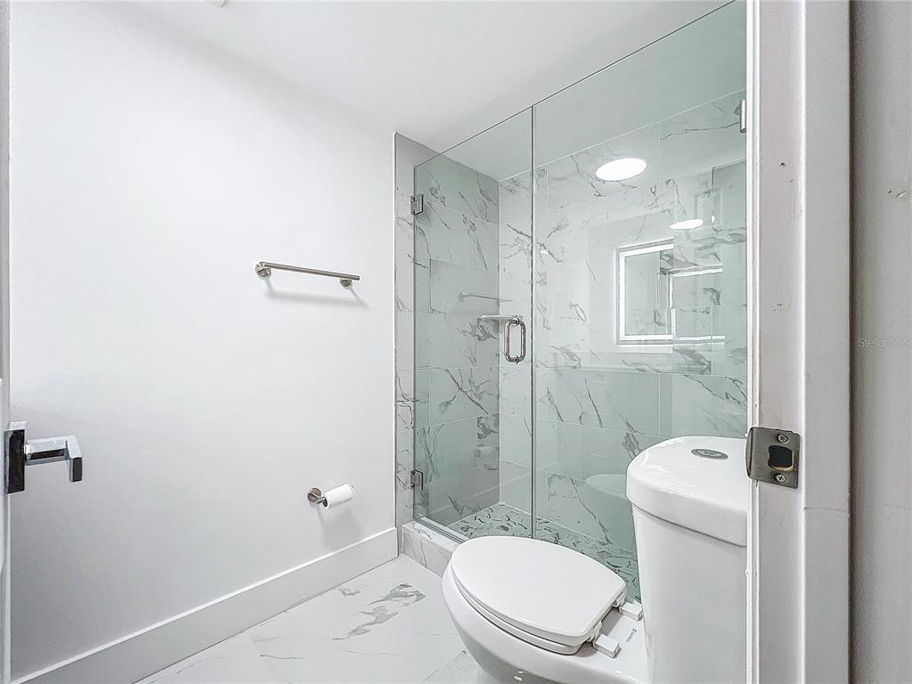 6233 Dewdrop Way Tampa, FL 33617 - Photo 16 of 30 a white toilet sitting next to a bathroom sink