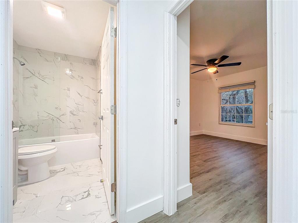 6233 Dewdrop Way Tampa, FL 33617 - Photo 25 of 30 a bathroom with a granite countertop toilet a sink and bathtub