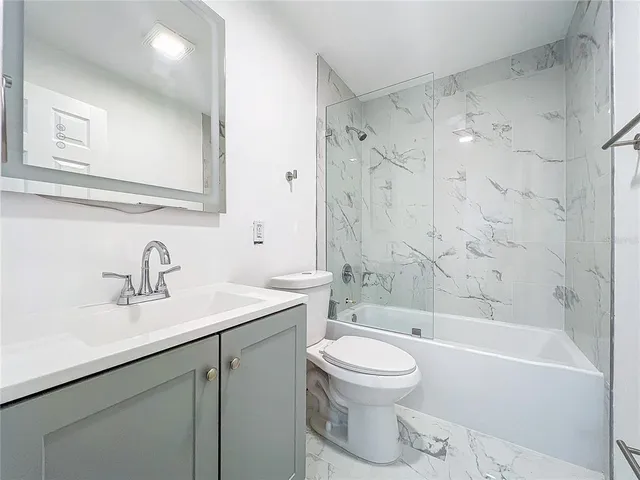 an empty room with wooden floor ceiling fan and window