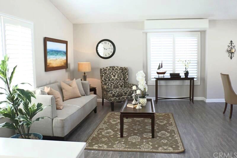 Living room with vaulted ceilings, a ton of natural light, beautiful plantation shutters.