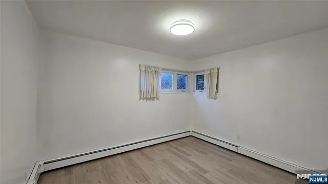 a view of a room with wooden floor and white walls
