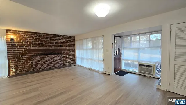 an empty room with wooden floor and fireplace