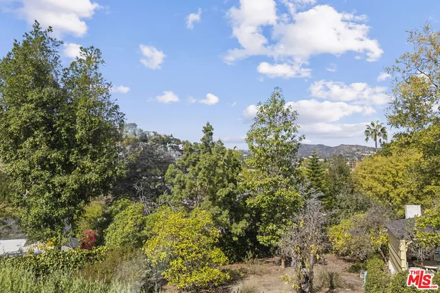 a view of empty room with wooden floor and window
