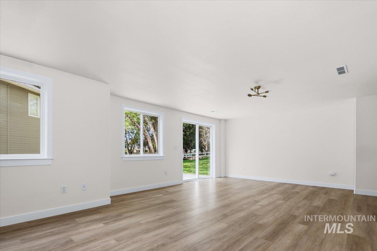 725 North Eagle Road Eagle, ID 83616 - Photo 27 of 45 Open-concept living space featuring wood-finish flooring, white baseboards, and neutral wall tones