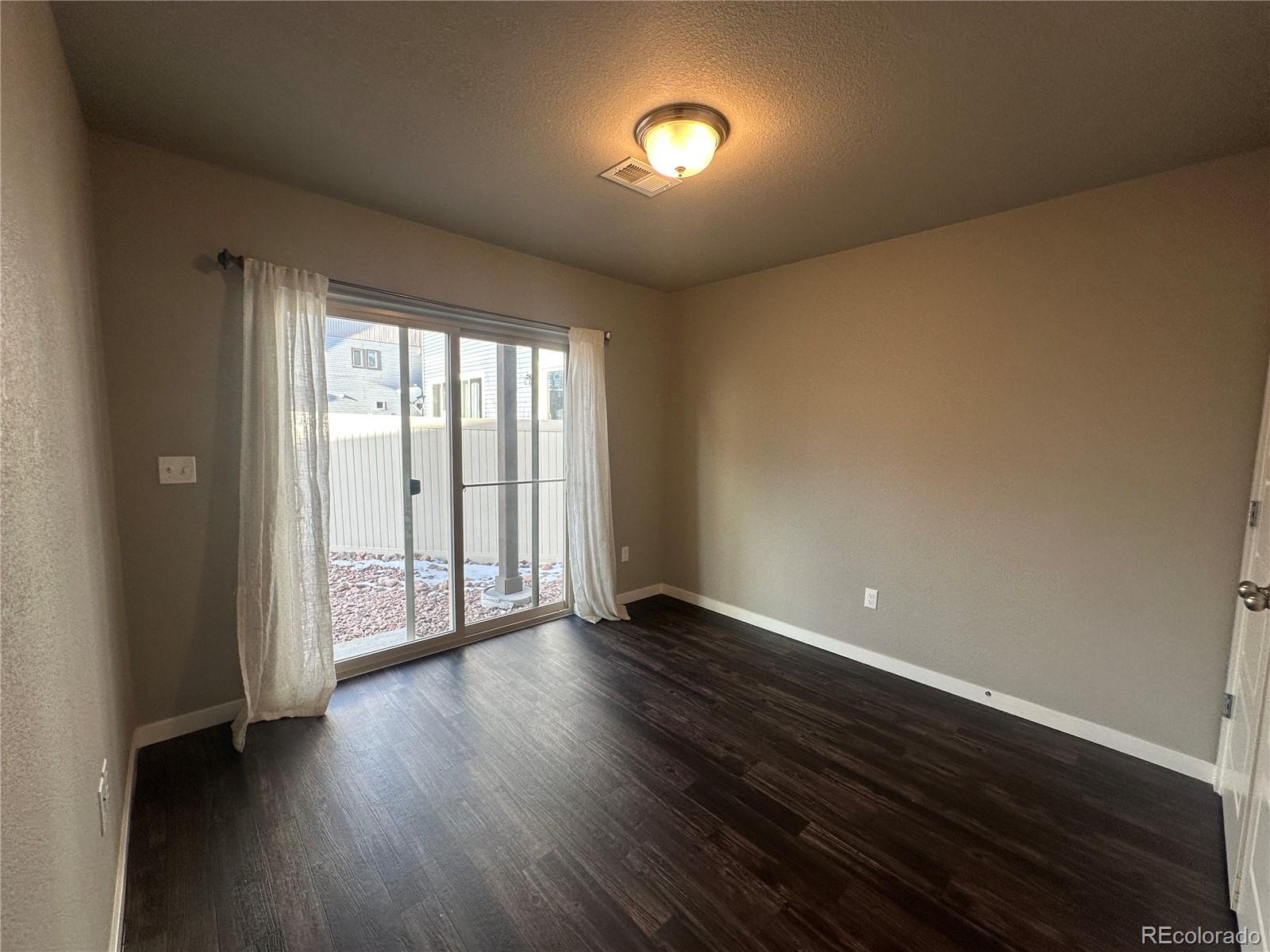 6612 Thicket Pass Lane Colorado Springs, CO 80927 - Photo 13 of 17 a view of an empty room with wooden floor and a window