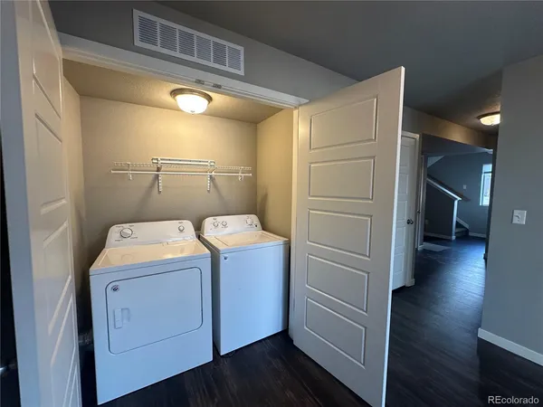 a view of storage and utility room with wooden floor