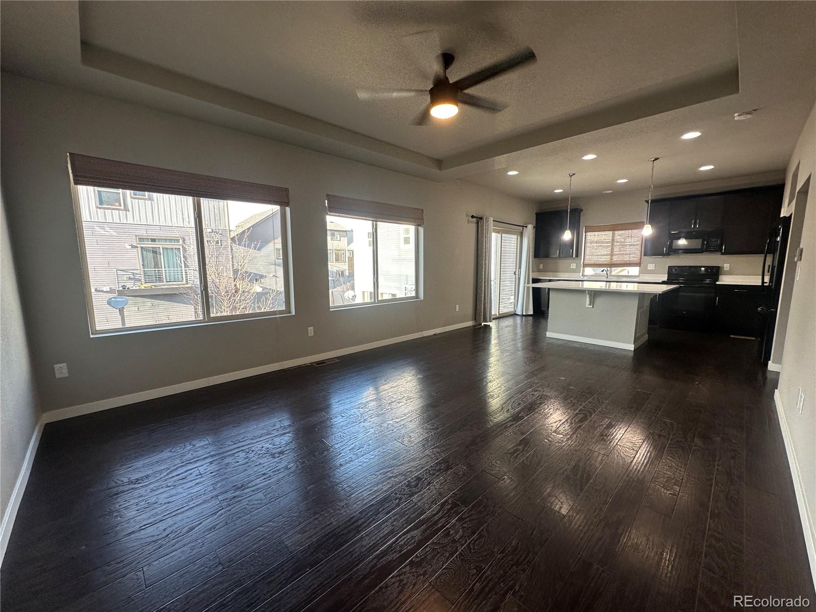 6612 Thicket Pass Lane Colorado Springs, CO 80927 - Photo 2 of 17 a view of an empty room with wooden floor and a kitchen