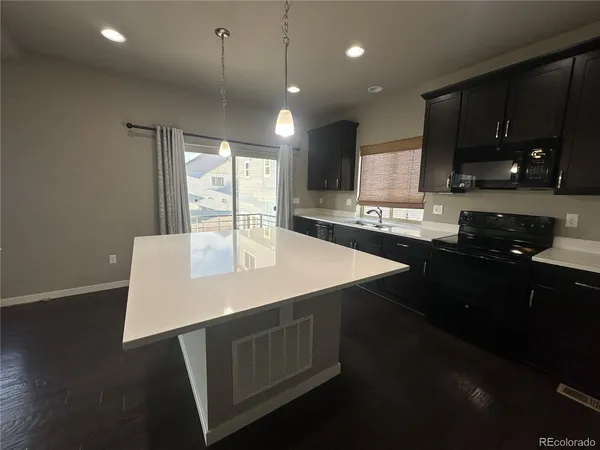 a kitchen with a sink a microwave and cabinets