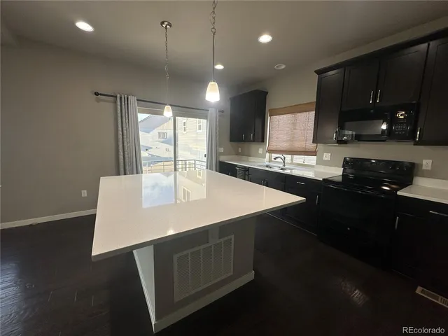 a kitchen with a sink a microwave and cabinets