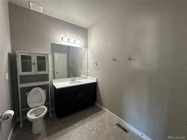 a bathroom with a sink vanity mirror and toilet