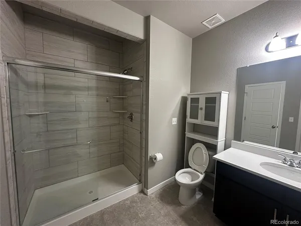 a bathroom with a toilet a sink and shower