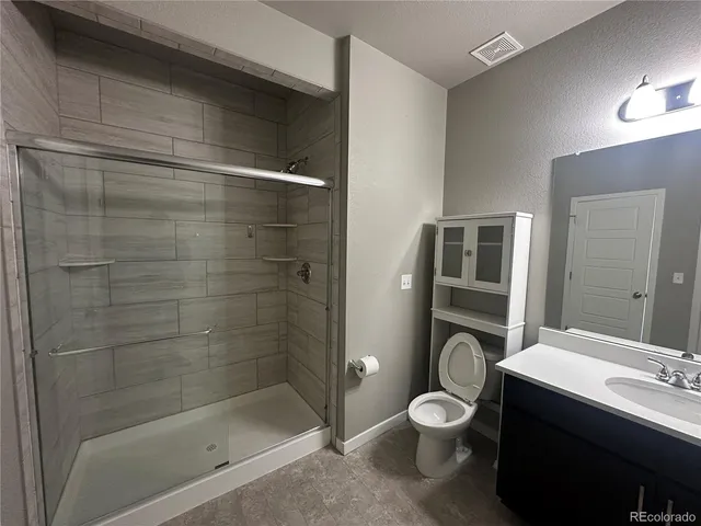 a bathroom with a toilet a sink and shower