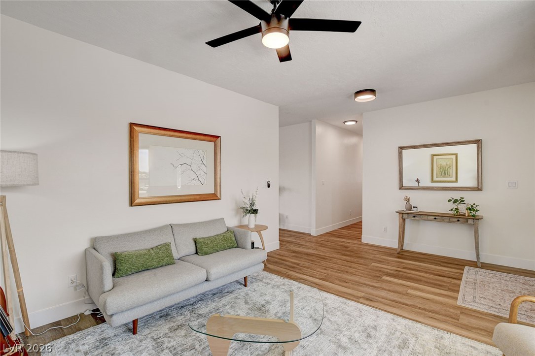 4362 Thistle Street Logandale, NV 89021 - Photo 10 of 99 A relaxed living area boasts clean lines, warm wood flooring, and modern lighting fixtures throughout.