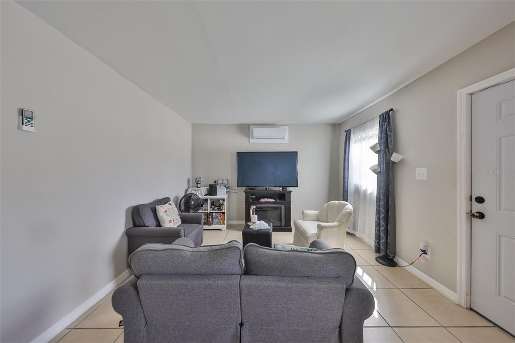 11708 Balm Riverview Road Riverview, FL 33569 - Photo 15 of 38 a living room with furniture a fireplace and a flat screen tv