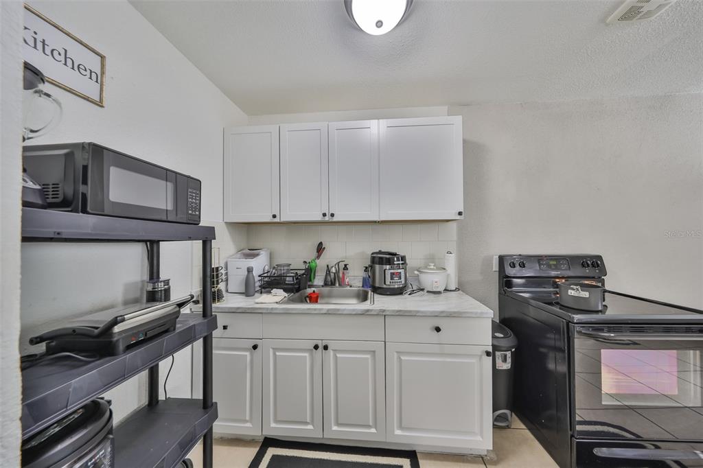 11708 Balm Riverview Road Riverview, FL 33569 - Photo 20 of 38 a kitchen with stainless steel appliances a stove a sink and cabinets