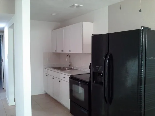 a kitchen with a refrigerator and a sink