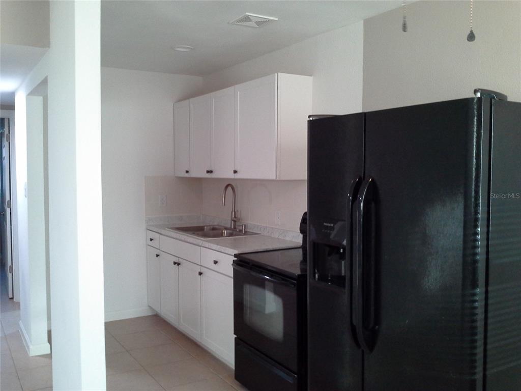 11708 Balm Riverview Road Riverview, FL 33569 - Photo 3 of 19 a kitchen with a refrigerator and a sink