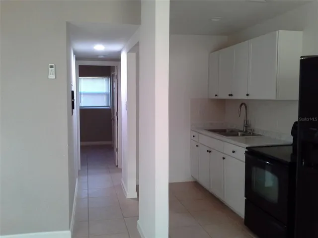 a kitchen with granite countertop white cabinets and a sink