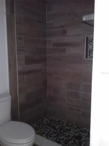 a bathroom with a toilet and a shower