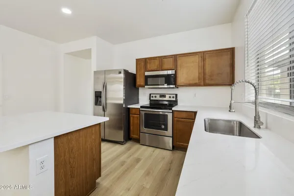 a kitchen with granite countertop a sink and steel appliances