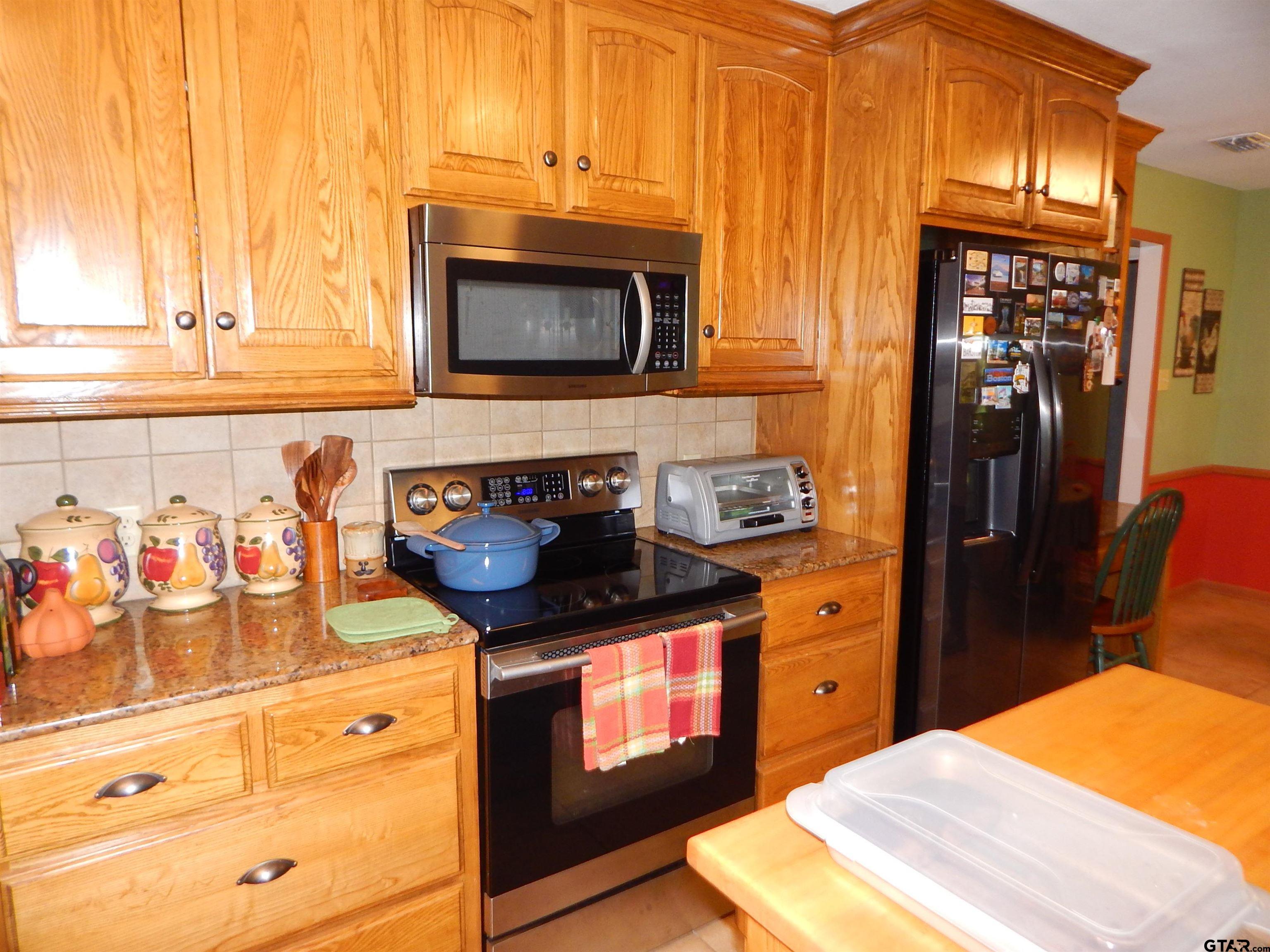 3035 Arrowwood Road Gilmer, TX 75644 - Photo 11 of 32 a kitchen with stainless steel appliances granite countertop a stove a sink and a microwave