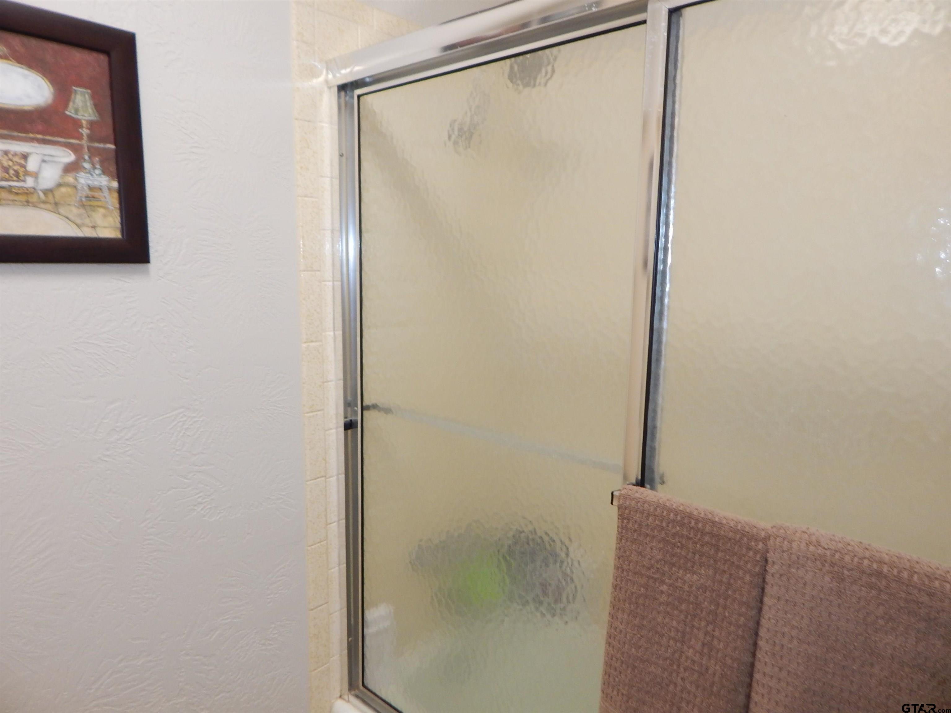 3035 Arrowwood Road Gilmer, TX 75644 - Photo 18 of 32 a bathroom with a glass shower door